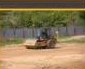 Roller compacting a graded pad